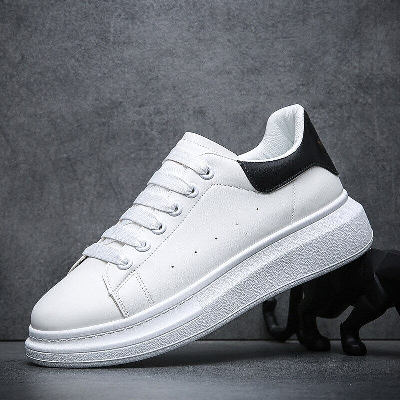 Zijaanzicht van wit met zwarte heren sneakers op een donkere ondergrond