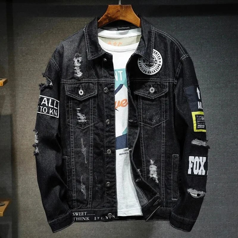 Zwarte heren denim jas met stoere rafels en patches hangend aan een hanger