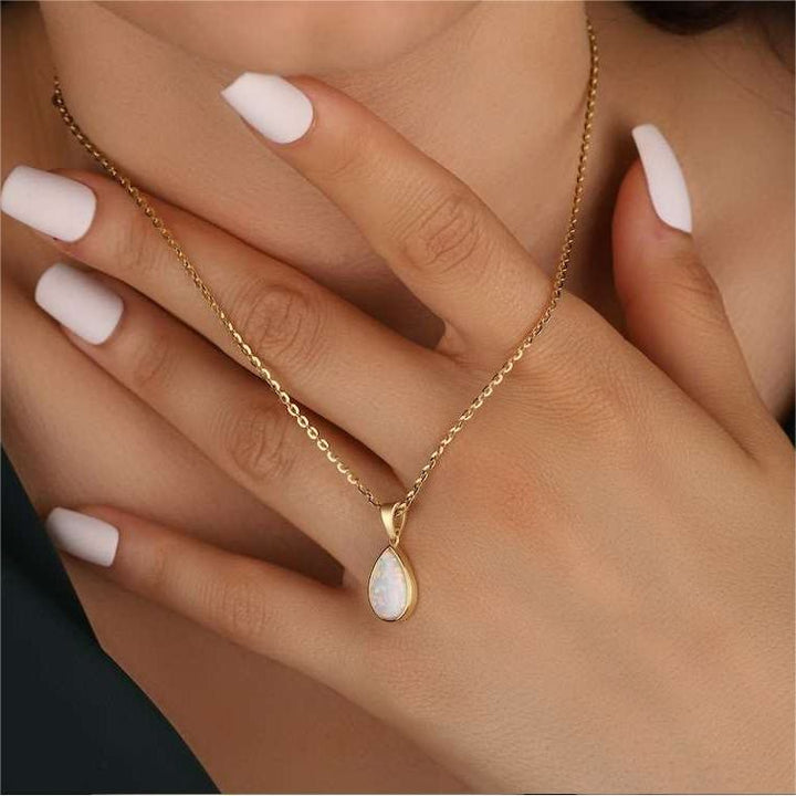 Natuurlijke opaal druppelhanger aan een 18K gouden ketting voor dames. Uniek en luxe sieraad.