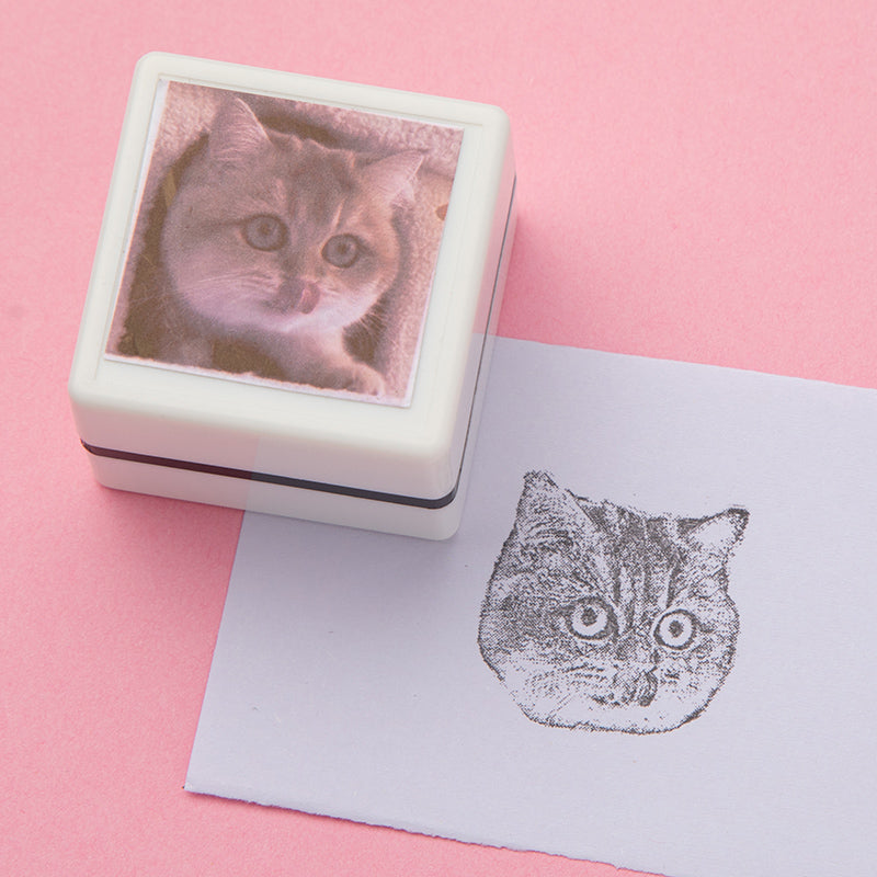 Zijaanzicht van een rubberen huisdier stempel met gravure van kattenportret.