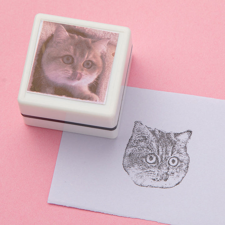 Zijaanzicht van een rubberen huisdier stempel met gravure van kattenportret.