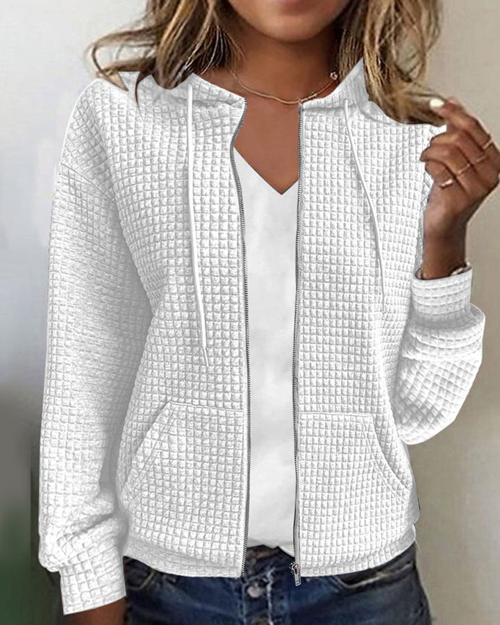 Model draagt een comfortabel losvallend damesvest met capuchon en zakken, perfect voor ontspanning of casual mode.