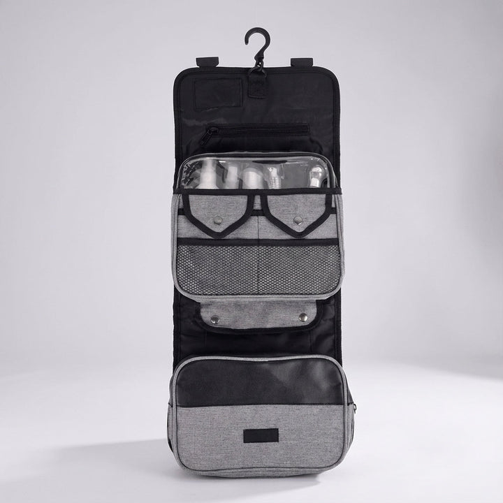 Gevouwen toilettas hangend aan een haak, ideaal voor badkamerorganisatie tijdens reizen. Ruim en compact.