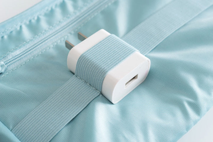 Open waterdichte elektronica organizer met diverse kabels, powerbank en opladers netjes gerangschikt.