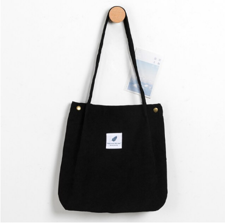 Dames corduroy totebag liggend op een tafel, klaar voor je volgende avontuur. Veelzijdig en ruim.