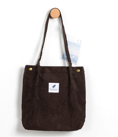 Model draagt casual corduroy dames totebag, perfect voor een dagje uit. Modieus en praktisch.