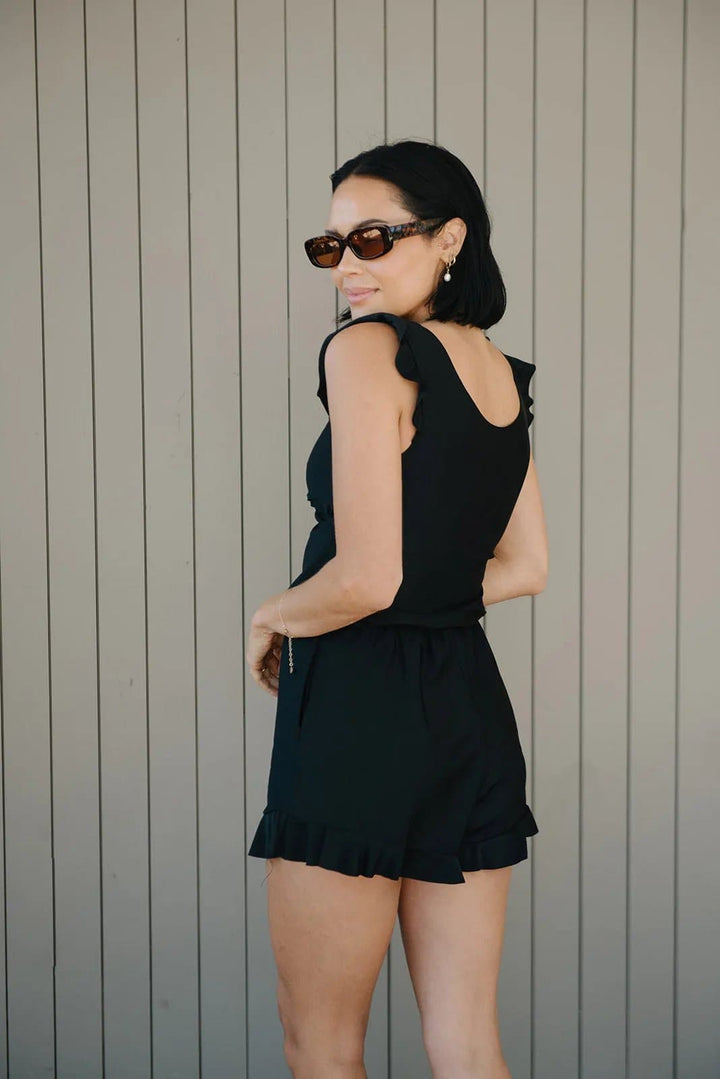 Vrouw ontspant op strand in stijlvol Nola dames badpak, comfortabele en trendy strandmode.