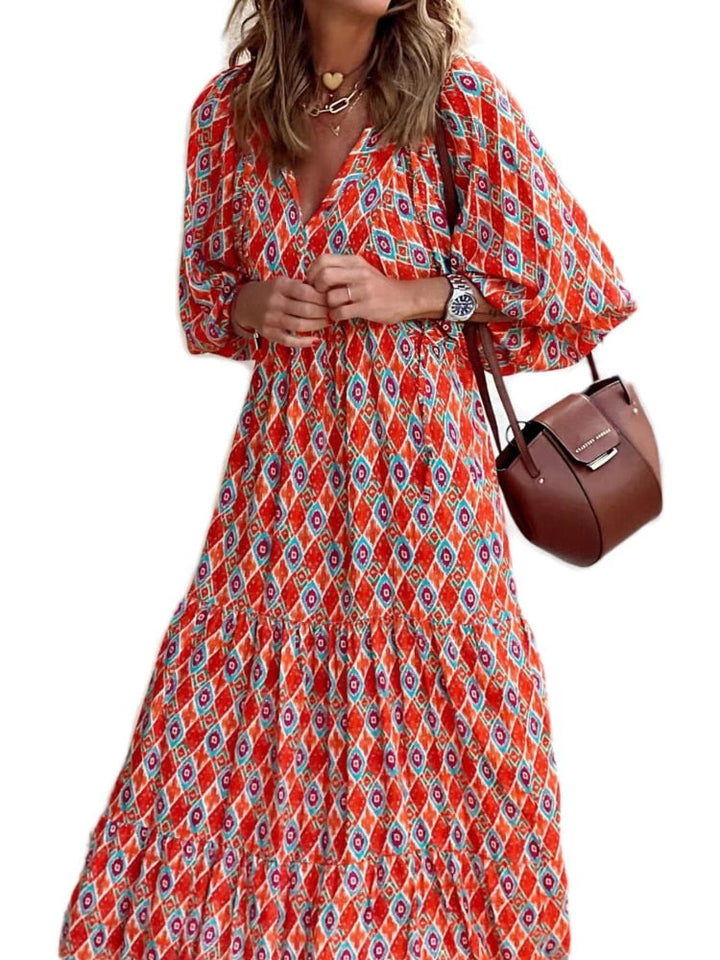 Vrouw loopt in een stijlvolle bedrukte maxi jurk met tailleband, perfect voor warme zomerdagen.