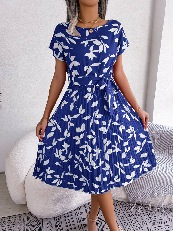 Dames blauwe bedrukte midi-jurk Naomi met flatterende riem. Elegante zomerjurk met patroon, getailleerd.