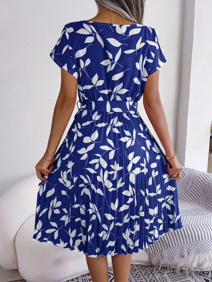 Getailleerde dames midi-jurk in blauw met opvallende print en flatterende riem. Ideaal voor de zomer.
