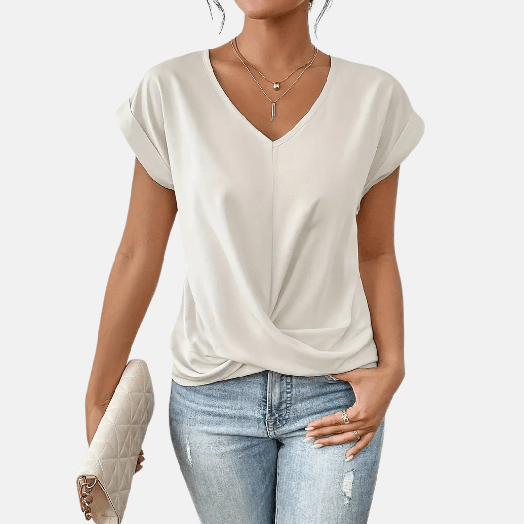 Modieuze dames kleding: effen blouse met V-hals en unieke gedrapeerde zoom, veelzijdig en elegant.