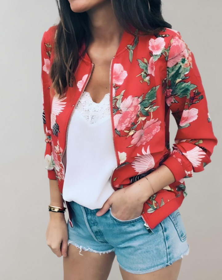 Vrouw draagt stijlvol dames bomberjack met bloemenprint. Trendy lentemode item.