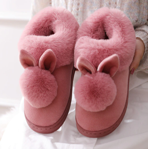 Vrouw draagt heerlijke dames bunny pantoffels, genietend van comfort en warme voeten thuis.