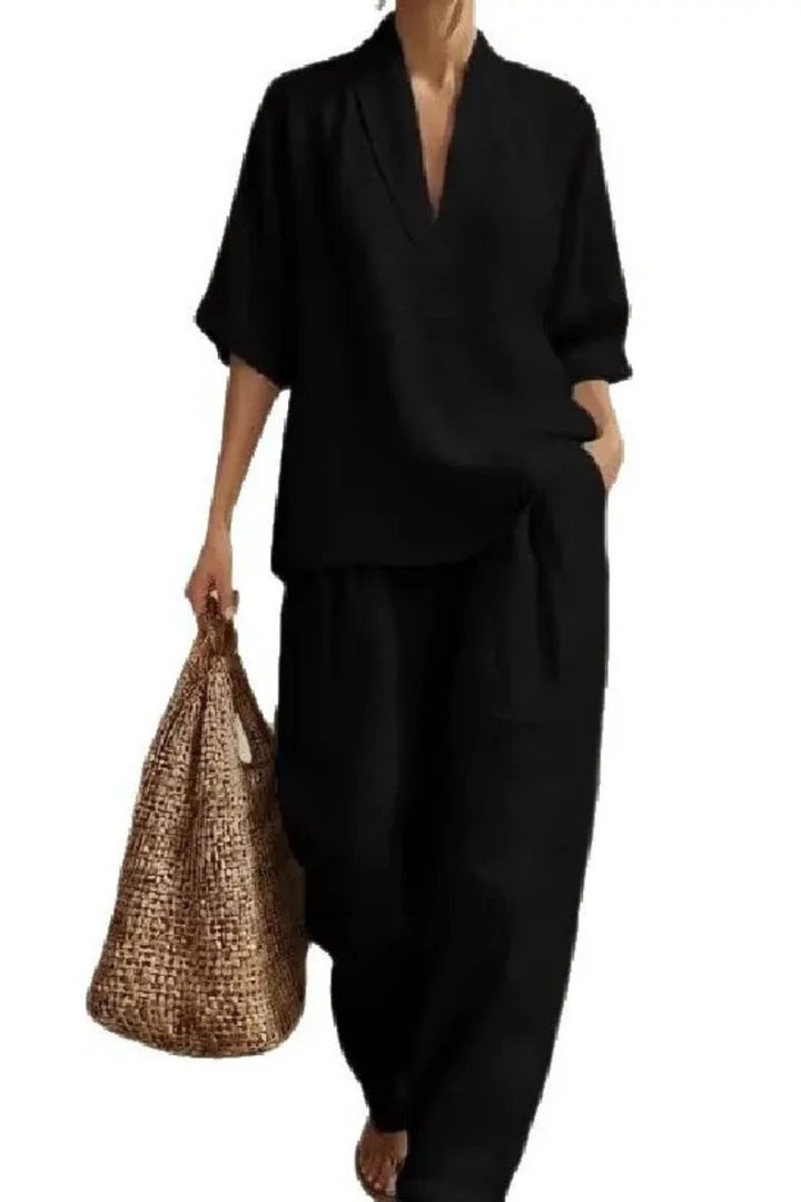 Zwarte damesset gecombineerd met een gevlochten tas voor een casual look