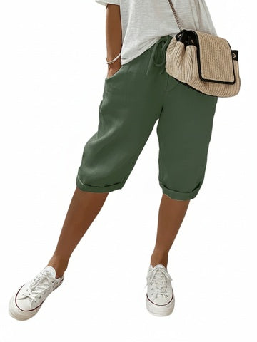 Dames driekwart broek in groen gecombineerd met sneakers en tas