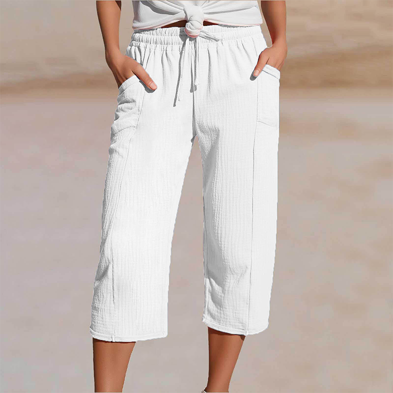 Vrouwenmodel toont witte driekwart broek met comfortabele pasvorm, perfect voor zomerse dagen.
