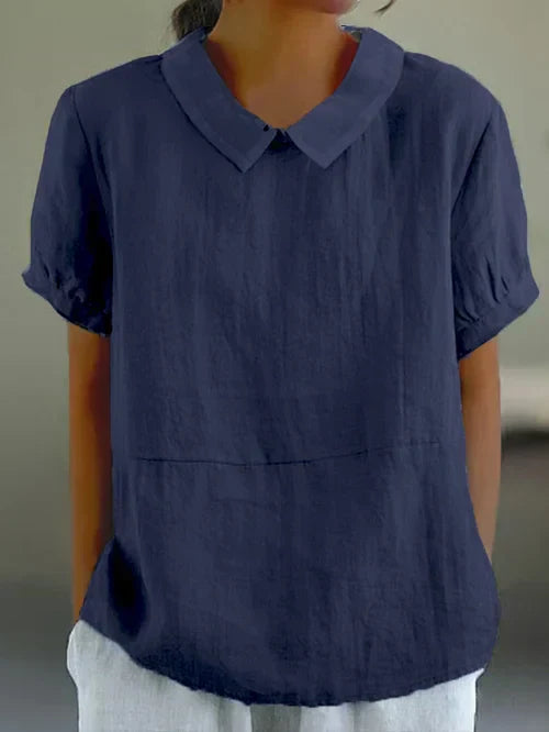 Witte dames zomerblouse met Peter Pan kraag en korte pofmouwen. Ideaal voor een chique, comfortabele outfit.