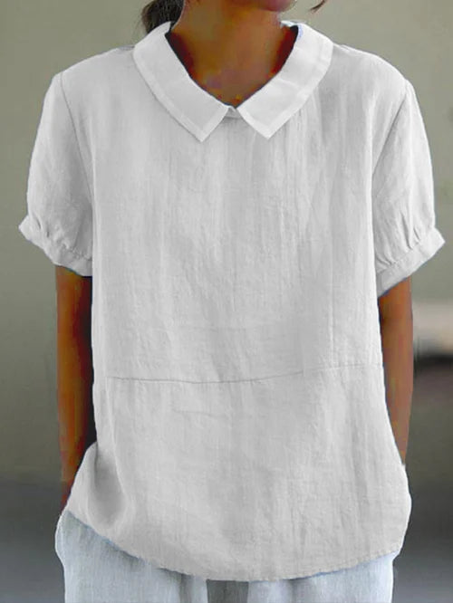 Elegante damesblouse met Peter Pan kraag en pofmouwen, een perfecte combinatie van comfort en verfijning voor de zomer.