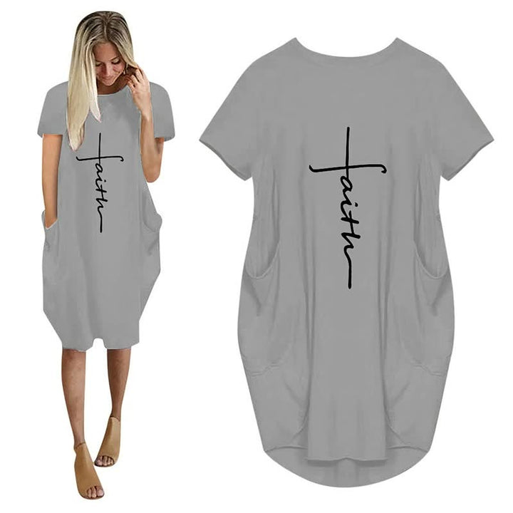 Vrouwenmode: zwarte oversized jurk met witte 3D letterprint en zakken, losse pasvorm. Stijlvol en praktisch.