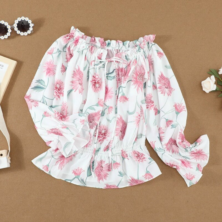 Zomerse gebloemde damesblouse met luchtige ruchesmouwen en een comfortabele pasvorm.