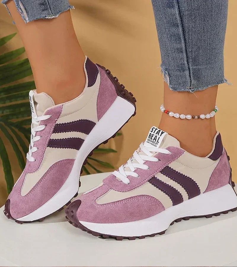 Voorzijde van gestreepte platform sneakers voor dames, met vetersluiting en duurzame zool.