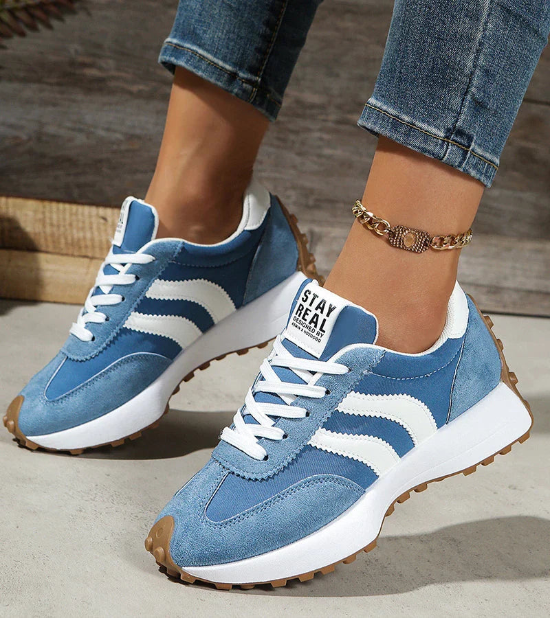 Detailbeeld: opvallende strepen op trendy dames platform sneakers met veters.