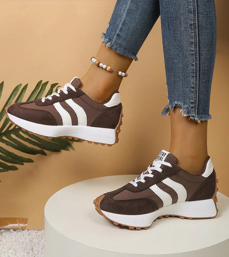 Witte dames sneakers met zwarte strepen en verhoogde platformzool; trendy en comfortabel.