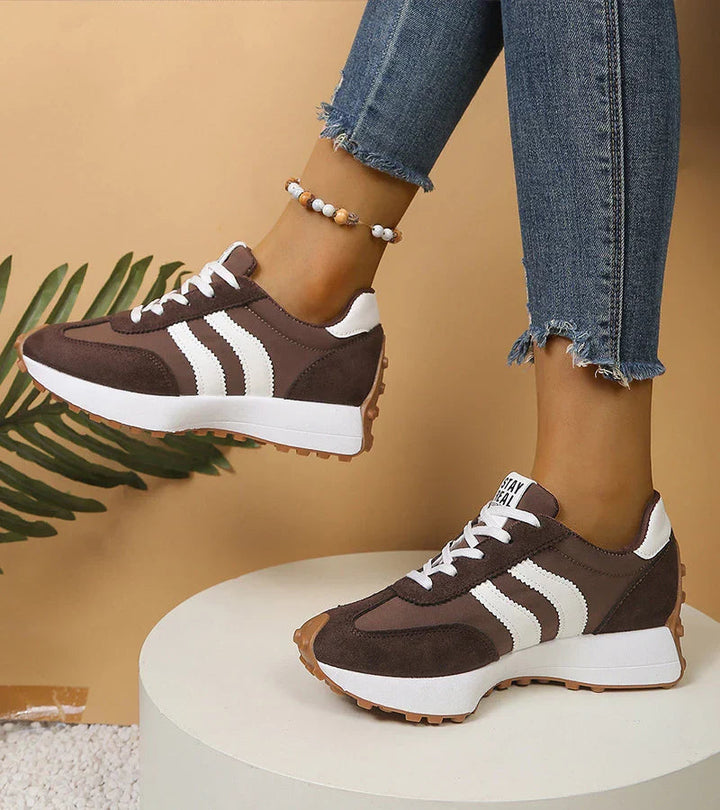 Witte dames sneakers met zwarte strepen en verhoogde platformzool; trendy en comfortabel.