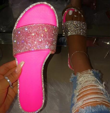 Dames glitter slippers met glimmende steentjes, gefotografeerd op een witte achtergrond, klaar voor de zomer.