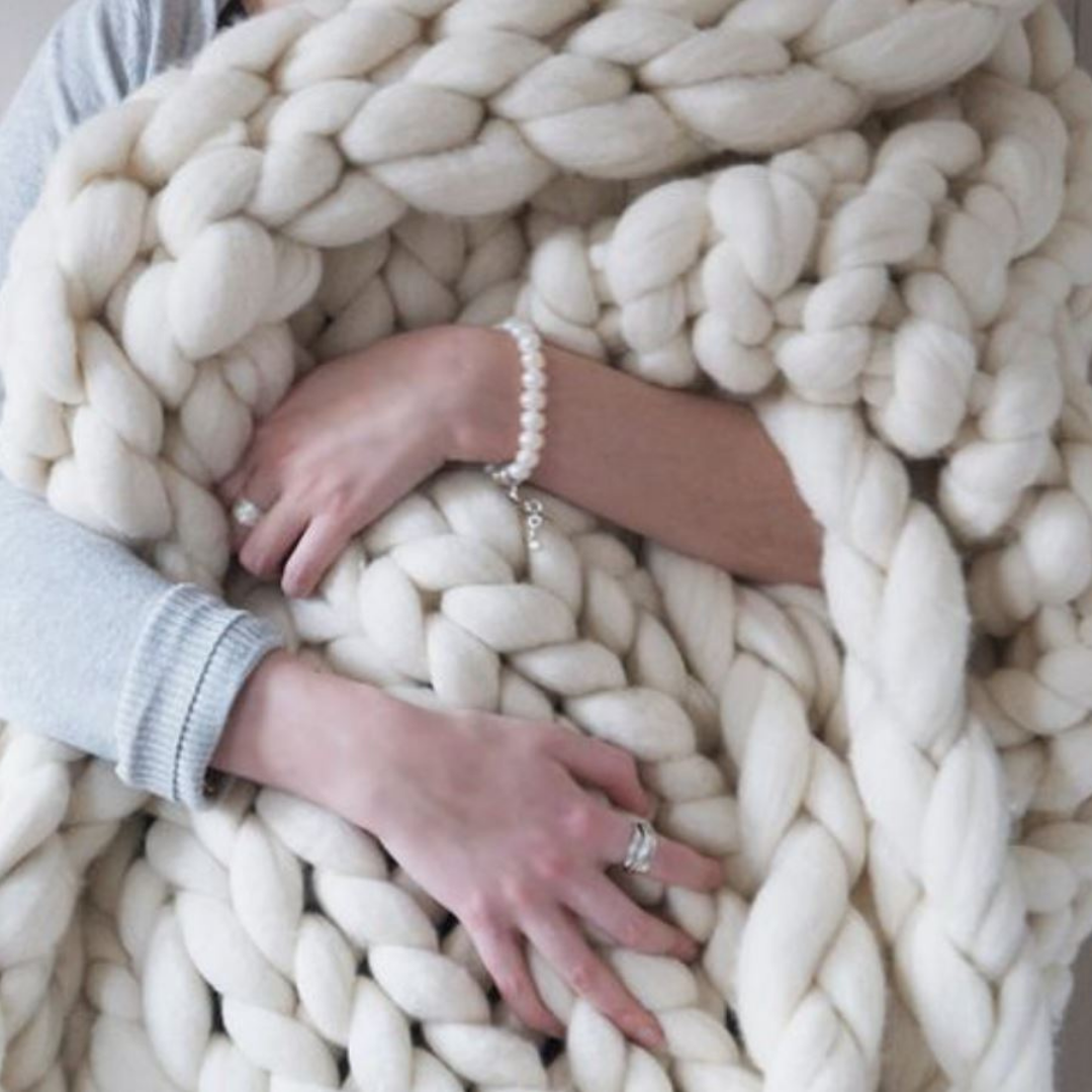 Comfortabele winterdeken voor dames, een grof gebreide toevoeging aan huisdecoratie.