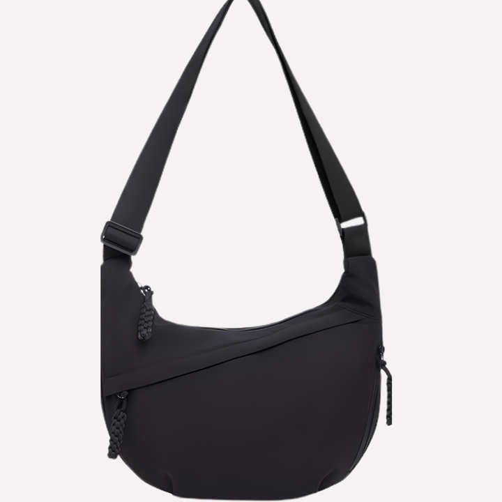 Vrouw draagt stijlvolle zwarte halvemaan crossbody tas, perfect als dagelijkse modieuze accessoire.