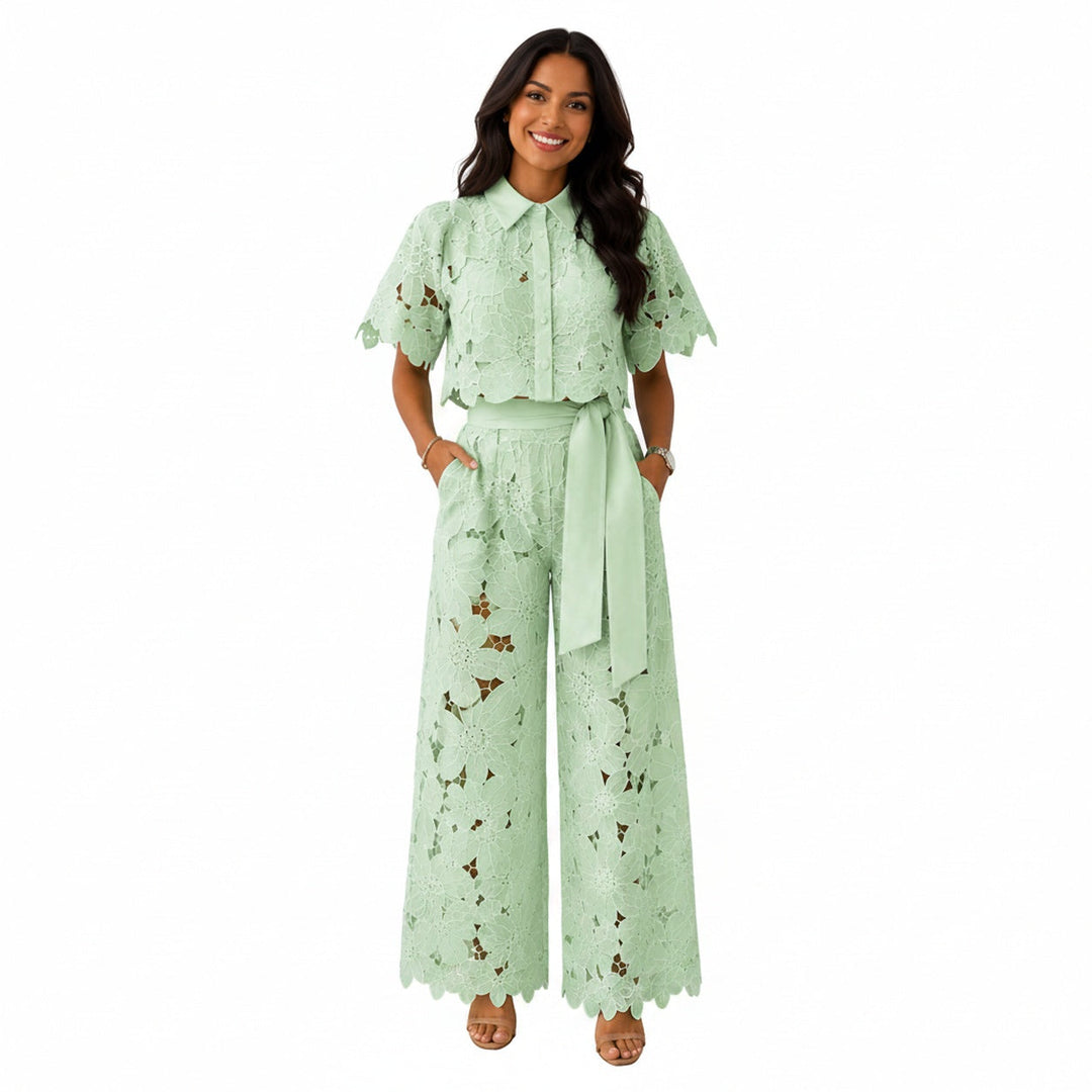 Model draagt een lichtgroene kanten crop top en wijde broek set met strikceintuur