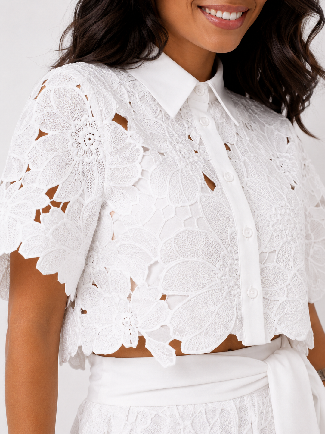 Detailopname van de witte kanten bloemen crop top met kraagje en knoopsluiting