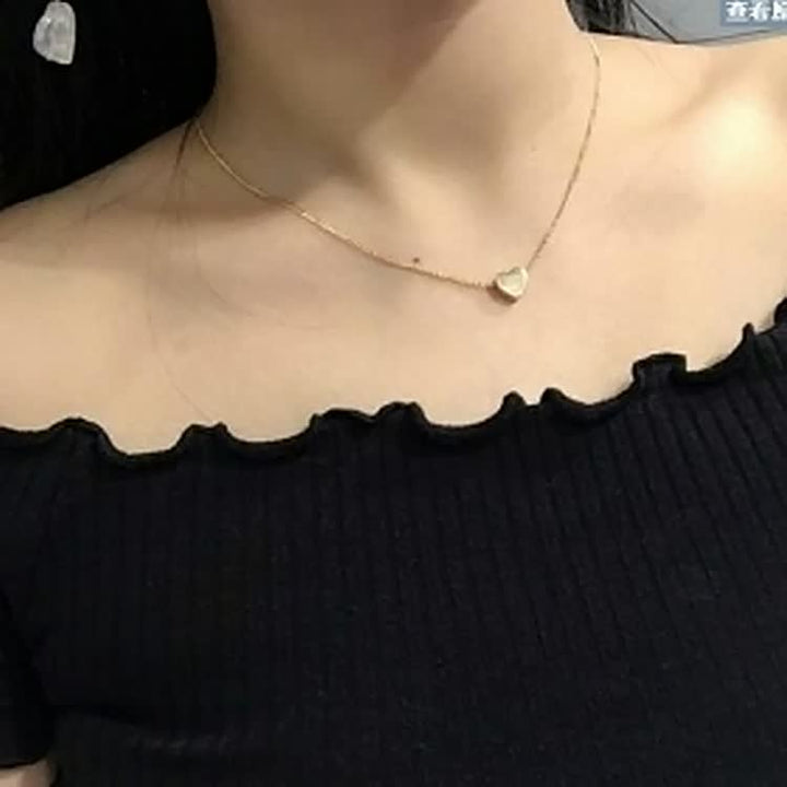 Close-up van een delicate hartje hanger aan een zilveren dames ketting, benadrukt detail.
