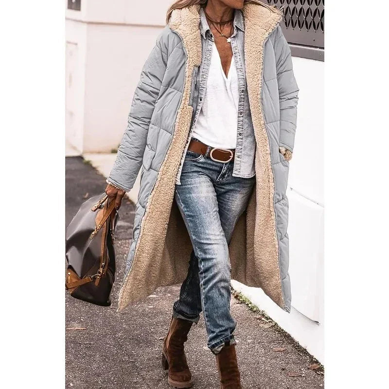 Vrouw in lange zwarte pufferjas met capuchon, warm en elegant. Stijlvolle dames winterjas.