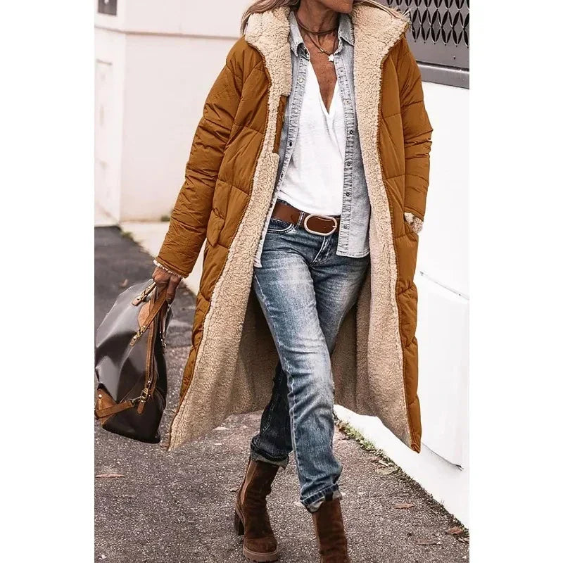 Zwarte lange dames pufferjas met capuchon, tijdloos en warm. Essentiële outwear voor de winter.