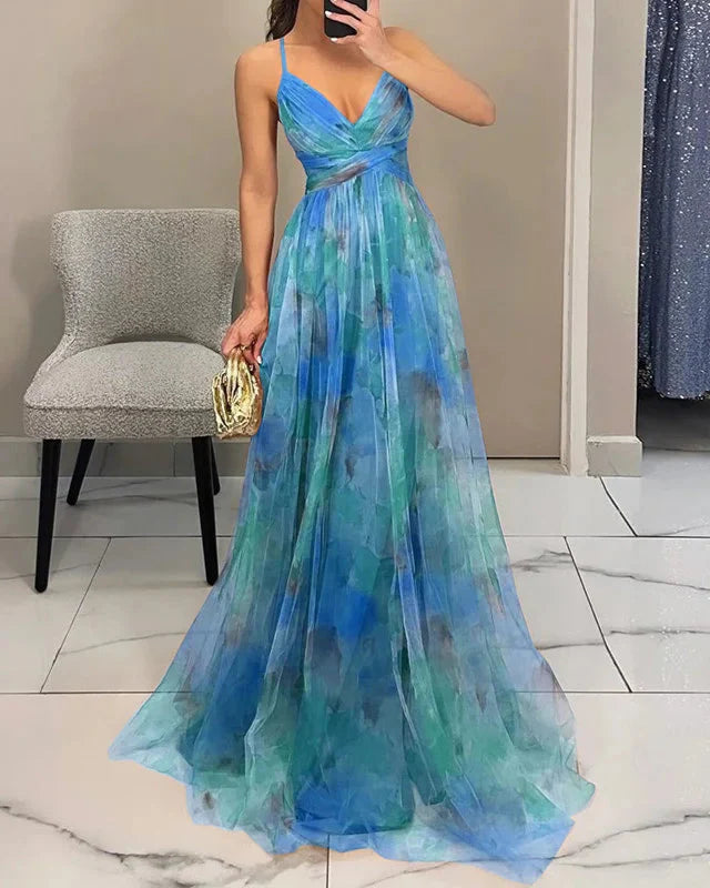 Vrouwen maxi jurk wapperend in de wind, bloemenprint, spaghettibandjes, perfect voor vakantie.