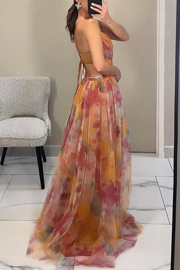 Model draagt lange dames zomerjurk met bloemen en spaghettibandjes, perfect voor een casual look.