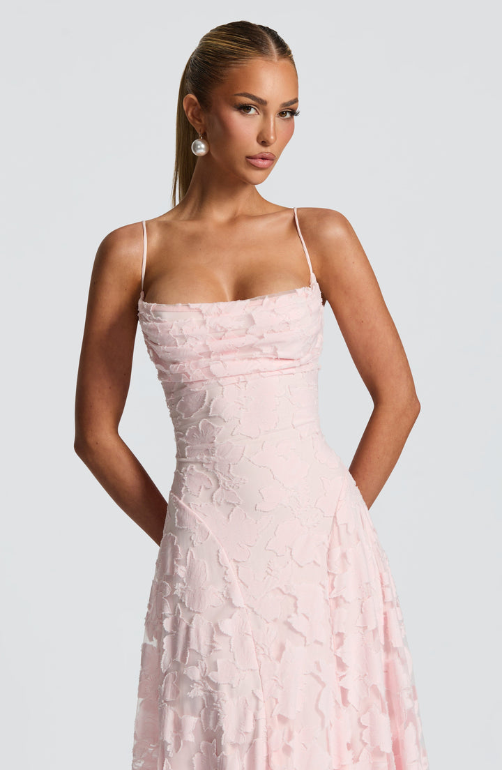 Maxi jurk met zomerse bloemenprint en spaghettibandjes. Beschikbaar in roze, groen, rood, ivoor.