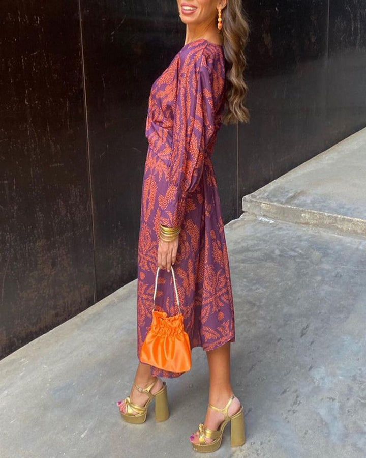 Prachtige dames maxi-jurk met all-over print, elegant twist detail en V-hals. Perfect voor elke gelegenheid.