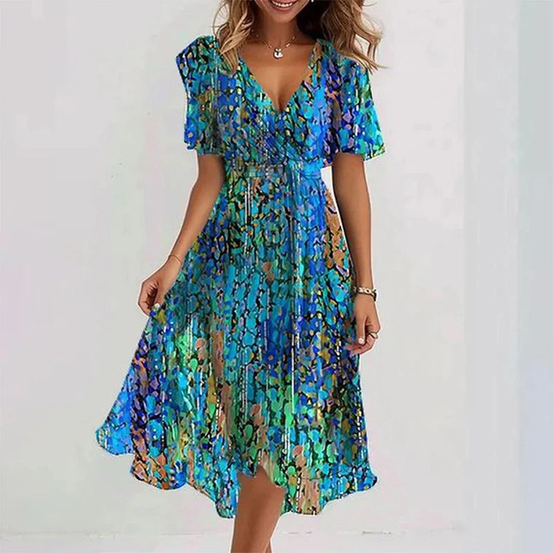 Lange dames midi jurk met bloemenprint, een elegante V-hals en vlindermouwen. Deze zomerjurk heeft een strikceintuur.