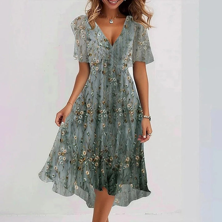 Elegante dames midi wikkeljurk met bloemenprint, v-hals en vlindermouwen. Perfecte zomer- of feestjurk met strikceintuur.