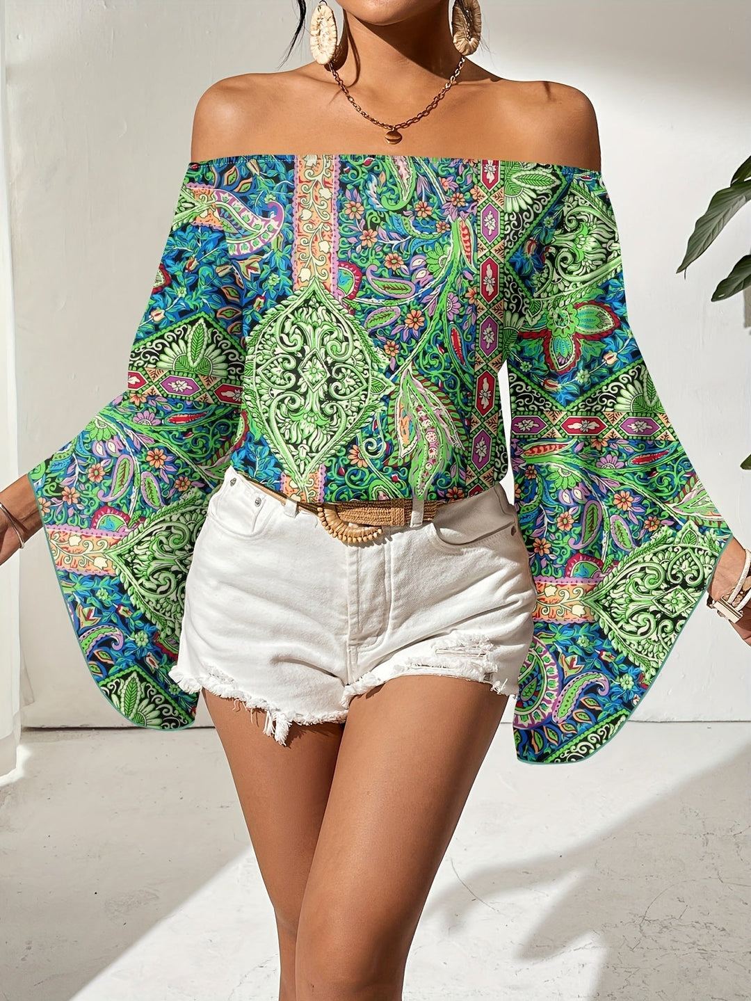 Elegante dames top met off-shoulder design en opvallende geometrische print, veelzijdig en chique.