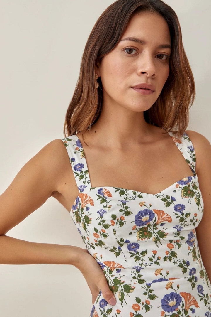 Model draagt een vrolijke dames Norelle midi-jurk met uitlopende pasvorm, bandjes en bloemenprint. Zomerse look.