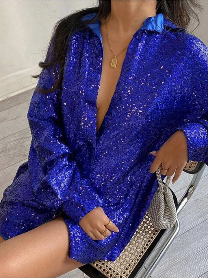Model draagt een chique oversized glitterblouse, gestyled voor een trendy en comfortabele look.