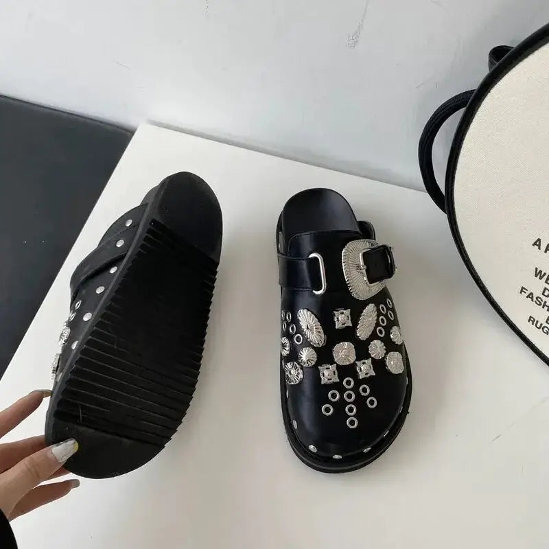 Zwarte plateausandalen voor dames, voorzien van zilverkleurige studs en een robuuste zool.