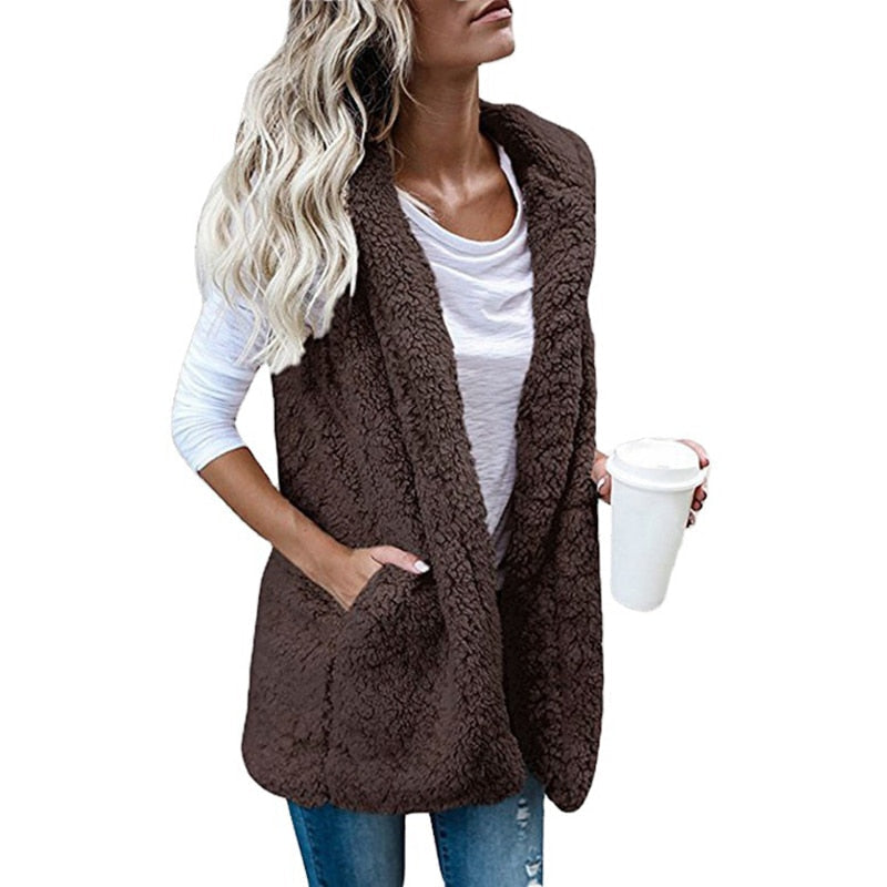 Vrouw draagt warm pluche mouwloos vest met capuchon als onderdeel van een stijlvolle winter outfit.