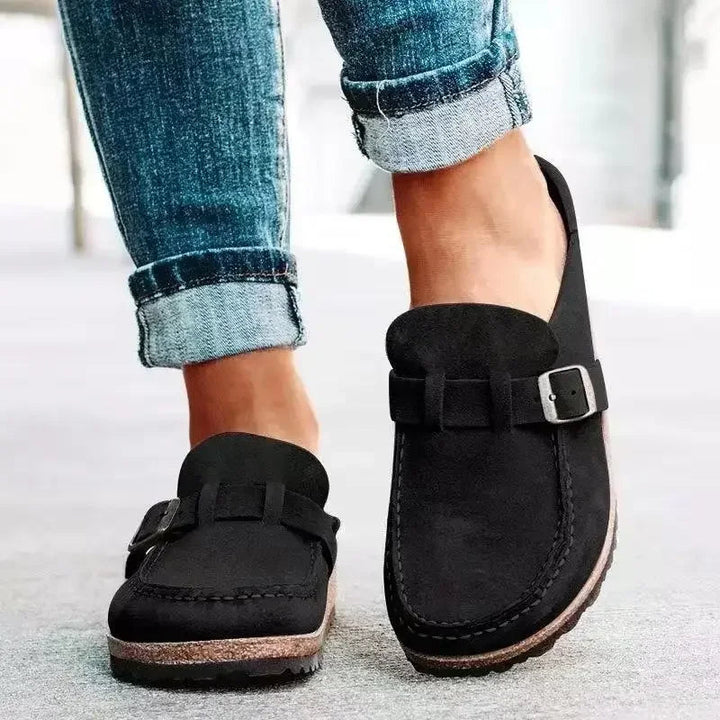 Stijlvolle retro dames muiltjes met gespdetail, ideale platte schoenen voor een casual lente of herfst look.