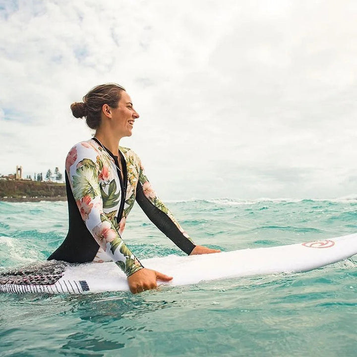 Trendy dames surfpak bodysuit. Kleurrijke zwemkleding voor watersport, stijlvolle strandmode voor de zomer.