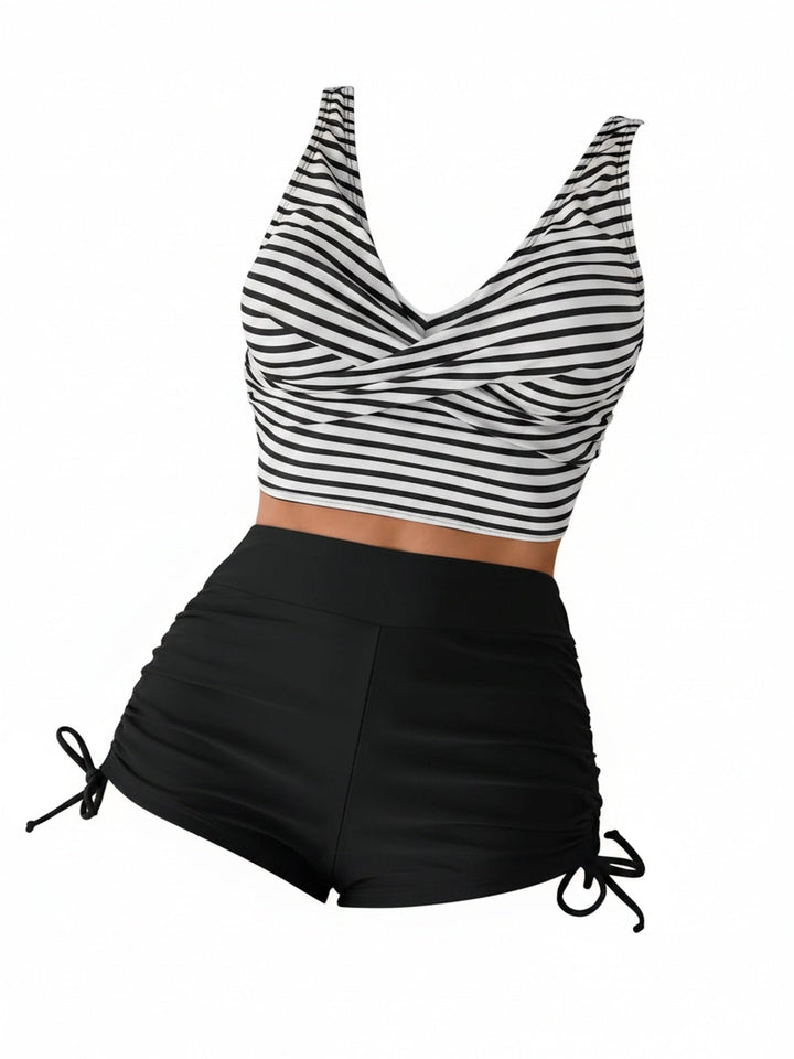 Dames tankini set met gestreepte twist front top en zwart hoge taille broekje op witte achtergrond